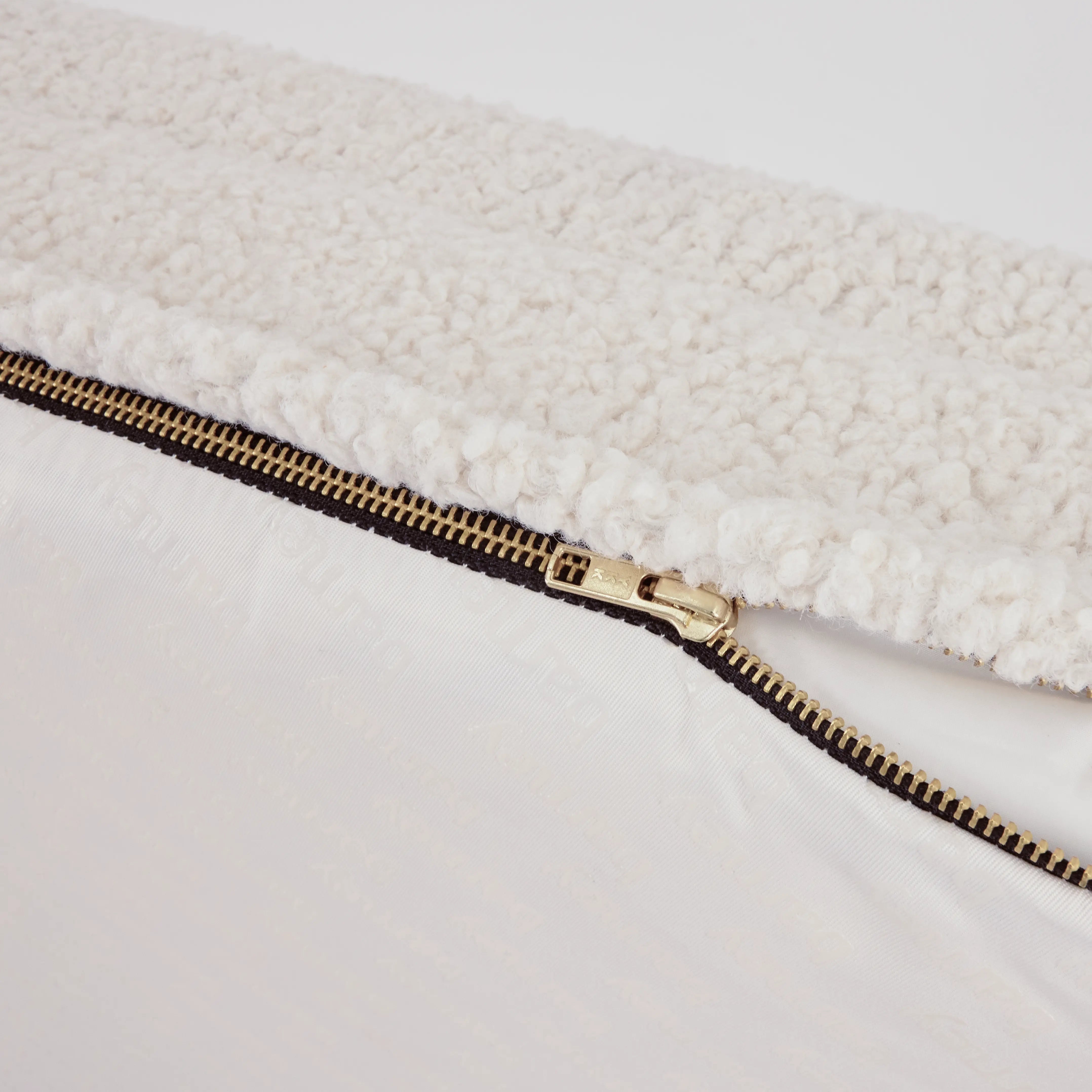Close-up of a white dog bed with a visible zipper detail