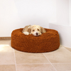 A dog rests on a medium-sized brown pet bed with a textured surface.
