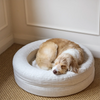 A dog sleeps comfortably on a linen-coloured pet bed