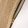 Close-up of a beige dog bed with a gold zipper detail.