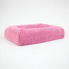 Pink luxury dog bed with a soft, textured surface designed for comfort and style