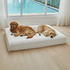 Golden Retrievers relaxing on a large white dog mattress